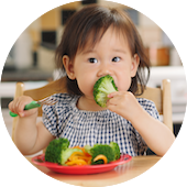 Toddler eating brocolli
